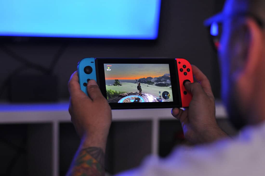 Boy playing Zelda on Nintendo Switch with blue light background