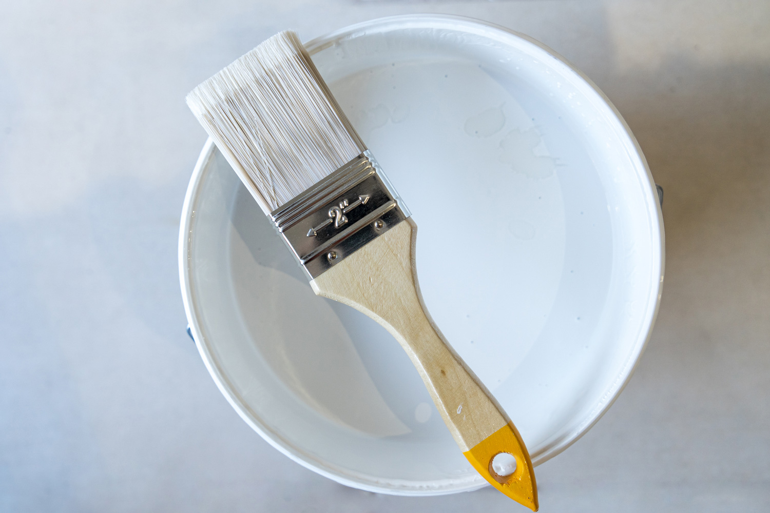 Close-up of Isolated bristle brush with white paint pot