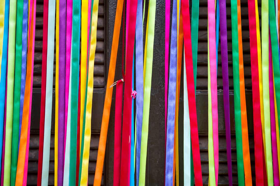 Colorful curtain of strips of decorative shiny carnival ribbon cover the entrance to a door