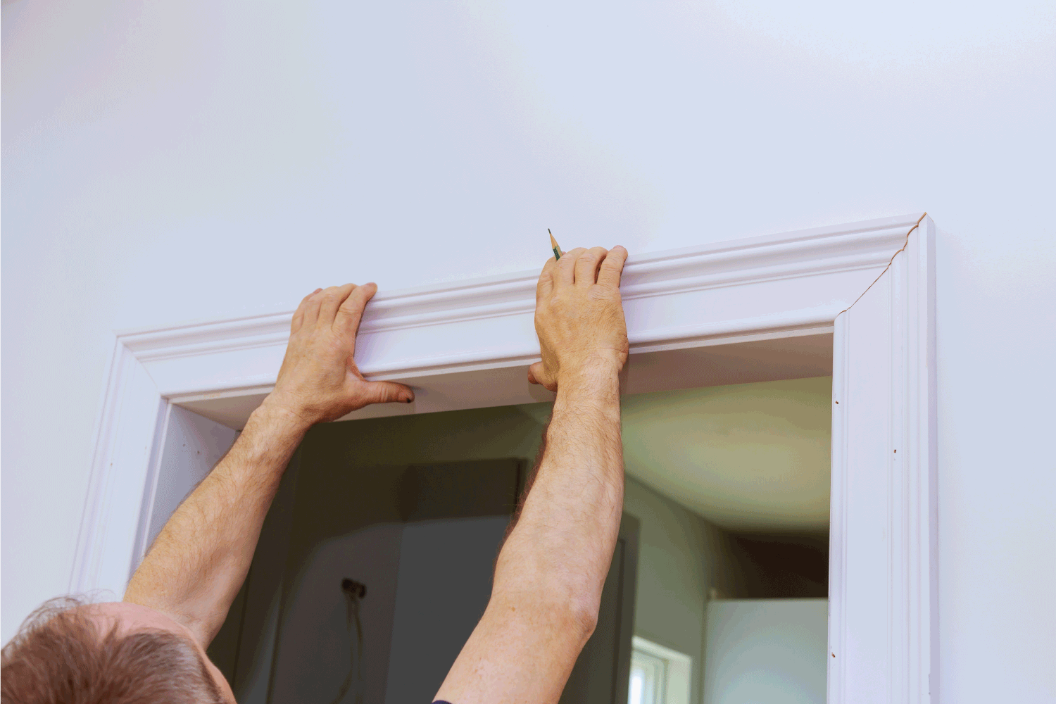 Construction handyman is working on renovation of apartment of door molding