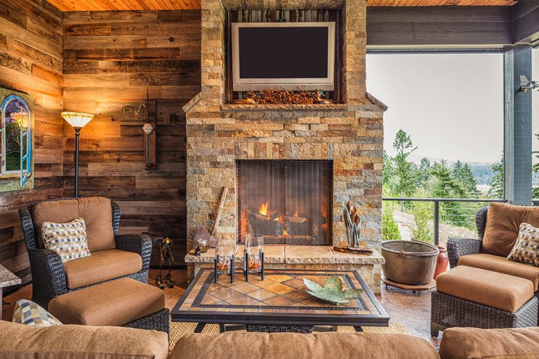 Covered Outdoor Patio Outside New Home with Couch Chairs TV Fireplace and Roaring Fire, How To Update A Stone Fireplace [8 Awesome Ideas]