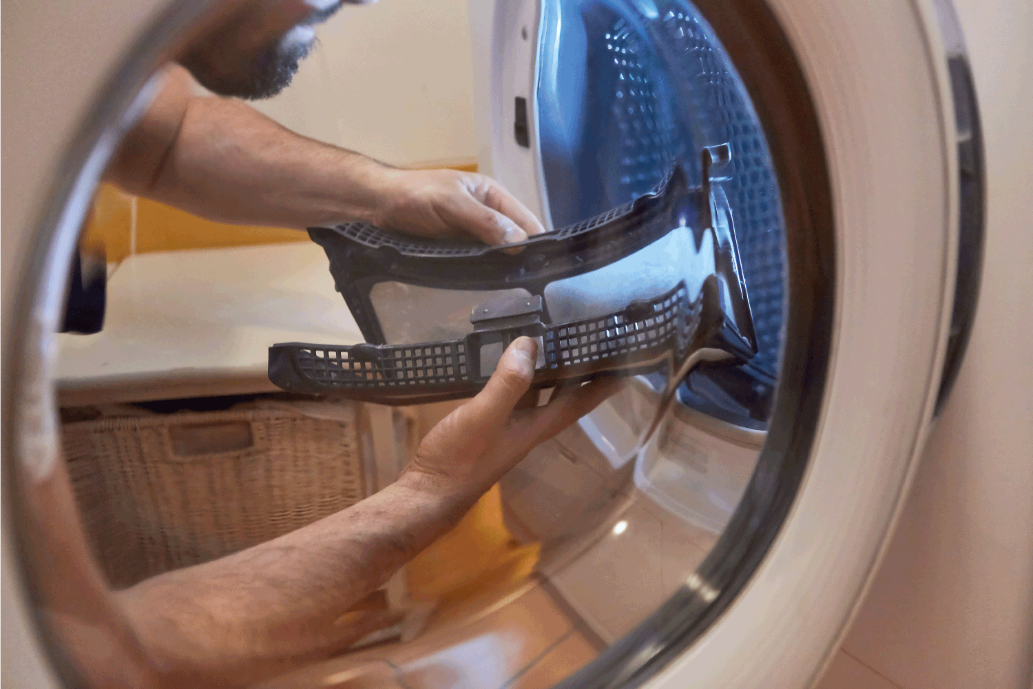 Craftsman cleans the lint filter from the tumble dryer in the bathroom or laundry room