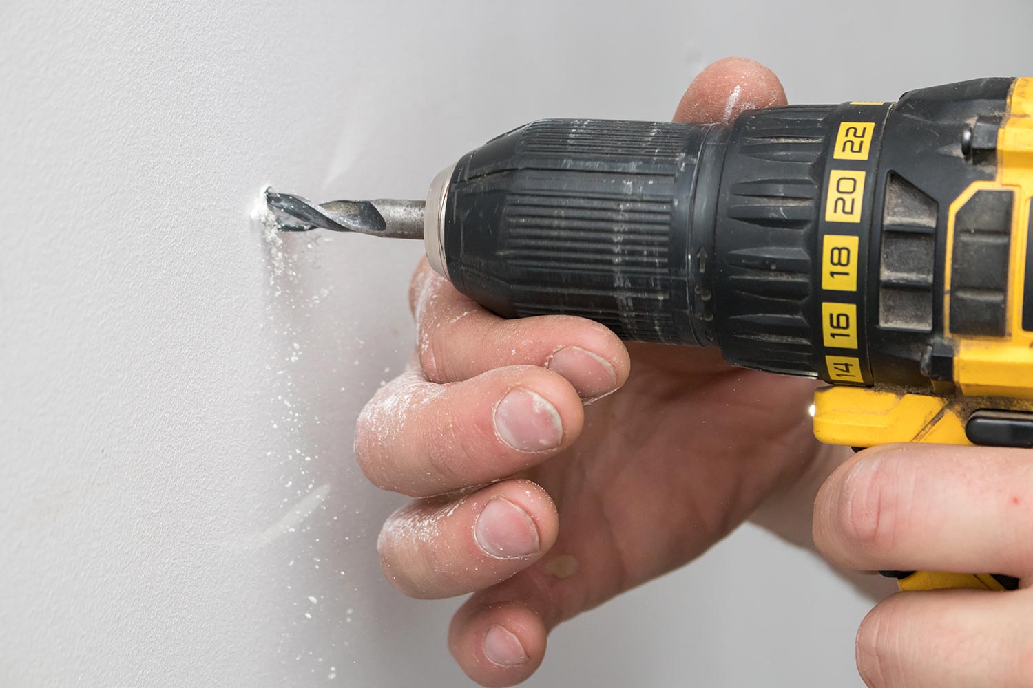 Drilling a white drywall wall