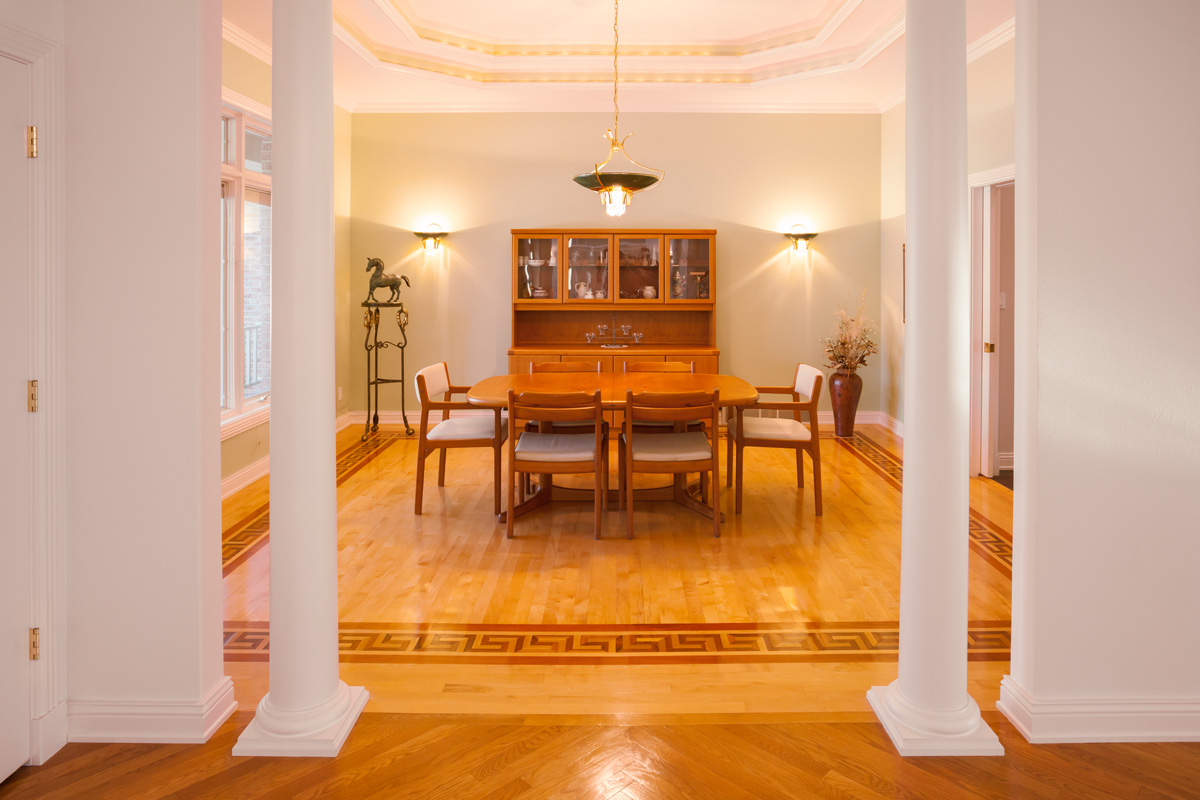 Elegant formal dining room with lighted tray ceiling, pillars.