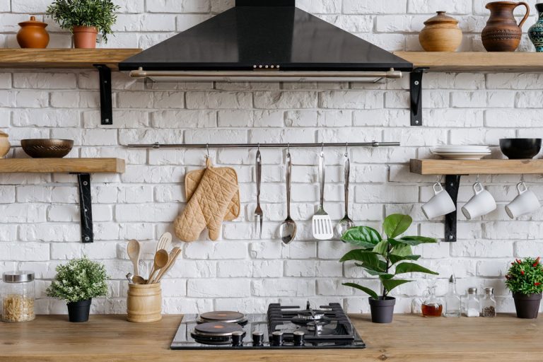 Element of kitchen appliance in apartment with modern interior, gas stove, cooking hood, kitchenware supplies, How Much Space Should You Have Between Hood And Range Should You Have?