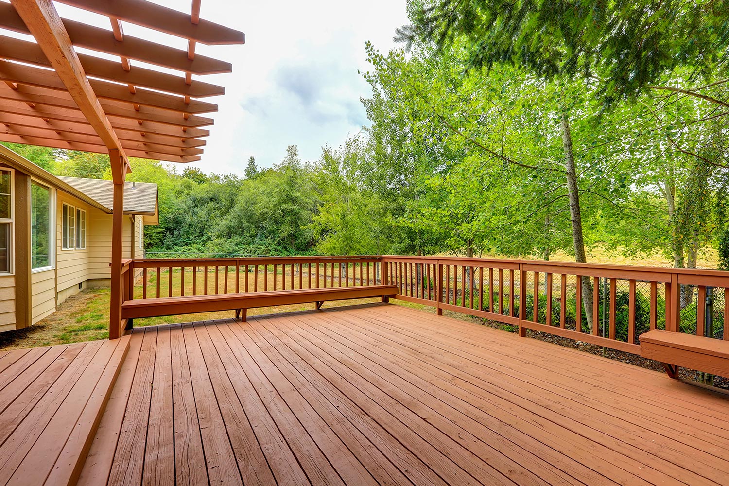 Exterior of horse ranch with empty wooden walkout deck
