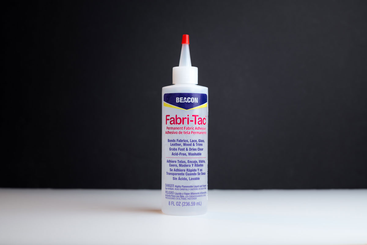 Fabri-Tac fabric adhesive on a semi transparent plastic bottle