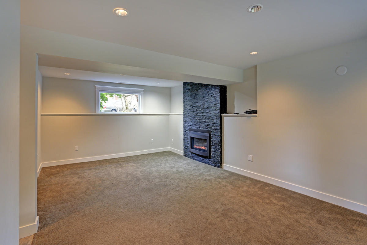 Fully renovated basement area with black fireplace