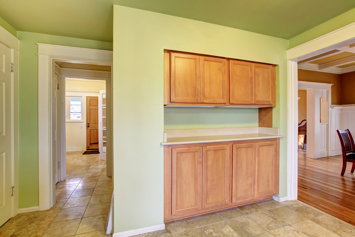 Green kitchen room with built-in light brown cabinets
