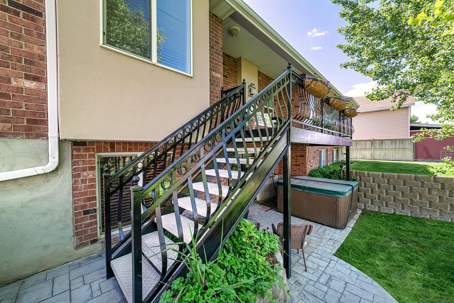 Home exterior with red bricks and staircase with metal railings