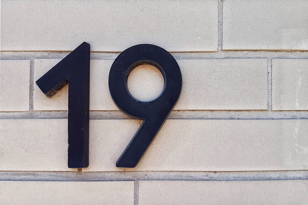 House number nineteen mounted on a wall