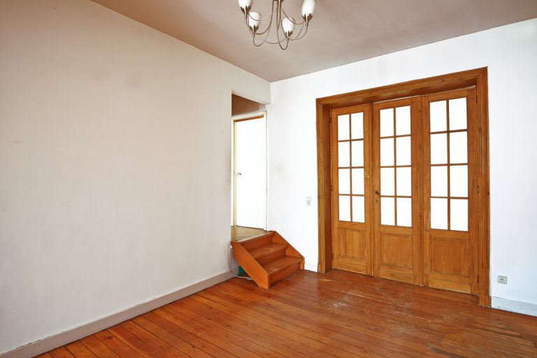 Interior aged wooden door with glasses frames in empty room, Do Accordion Doors Block Sound?