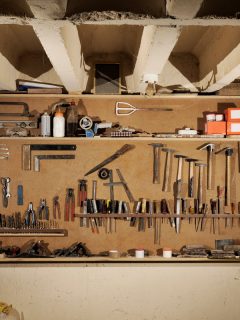 Interior of a garage with tools hanged on a board, How Much Space Between Garage Shelves Should You Have?