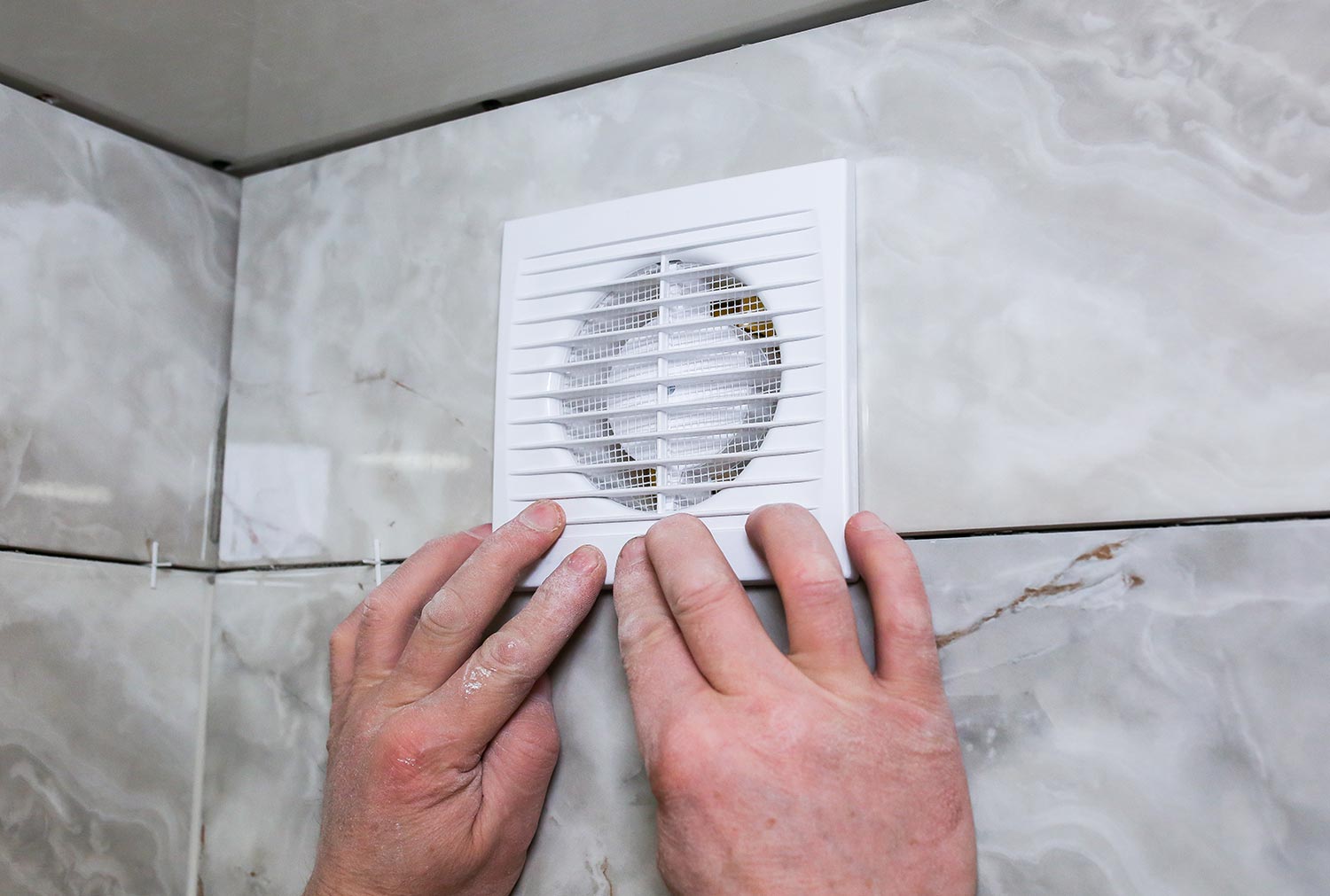 Man is making the wall bathroom fan vent