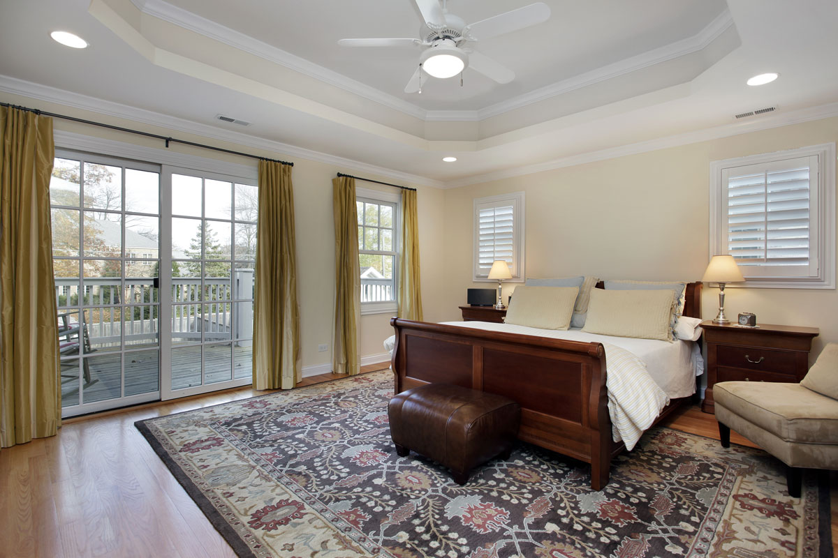 Master bedroom with tray ceiling and deck view