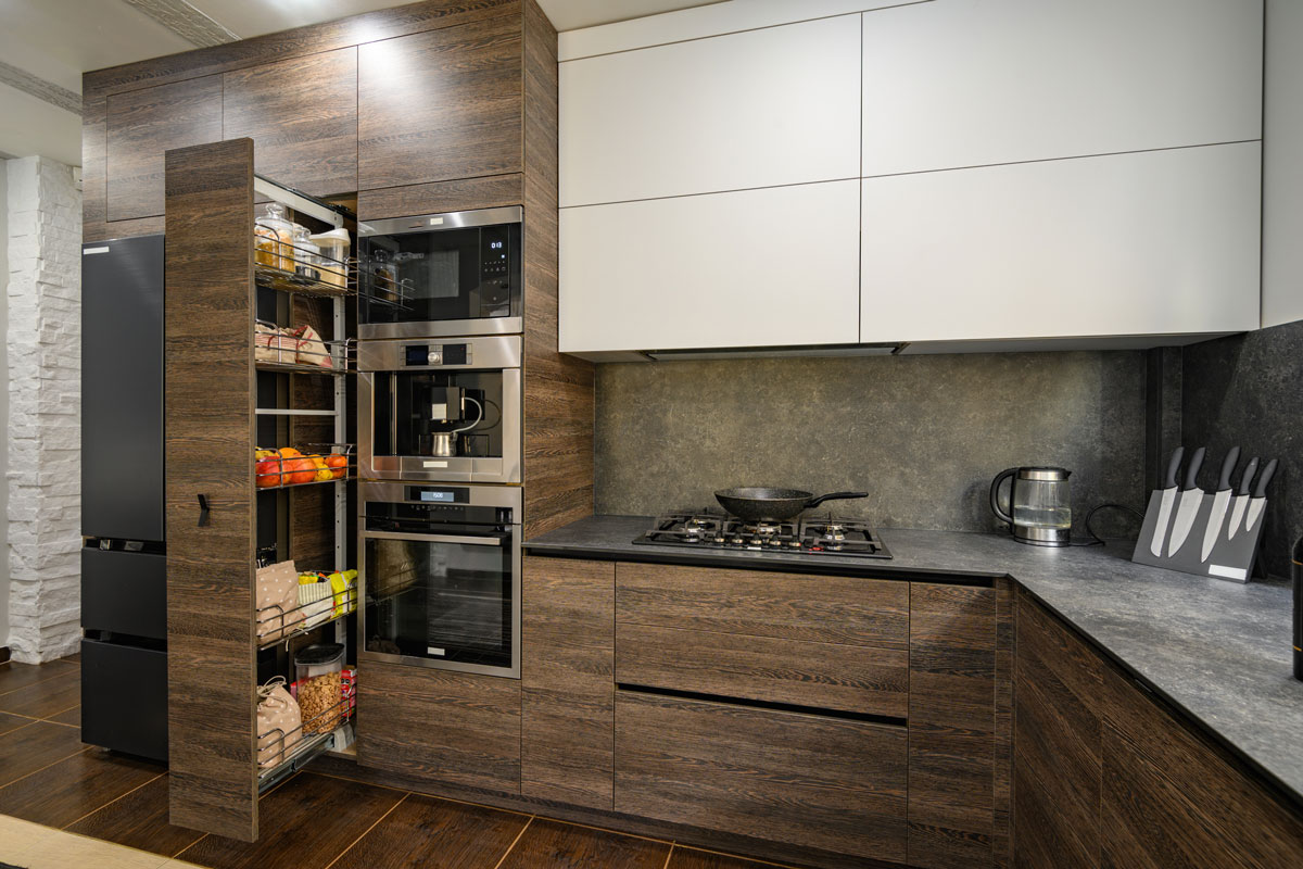 Modern large luxurious dark brown, gray and black cozy kitchen interior, big vertical drawer pulled out