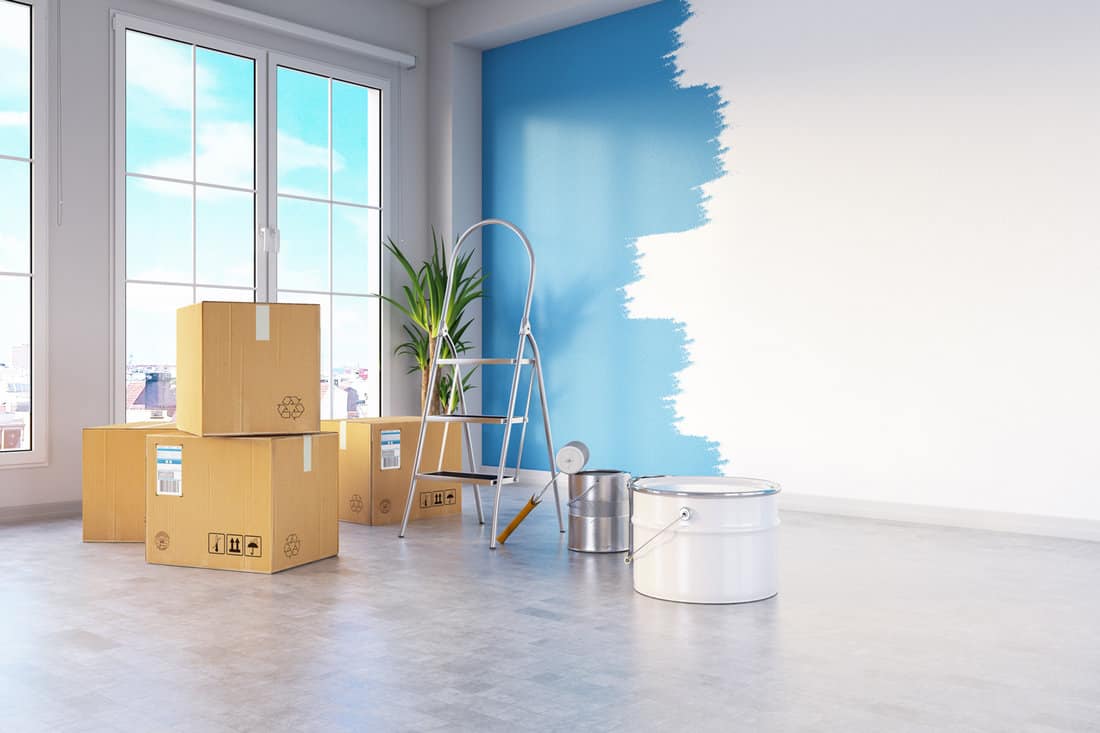 Moving House Concept with Cardboard Boxes and Wall Painting.