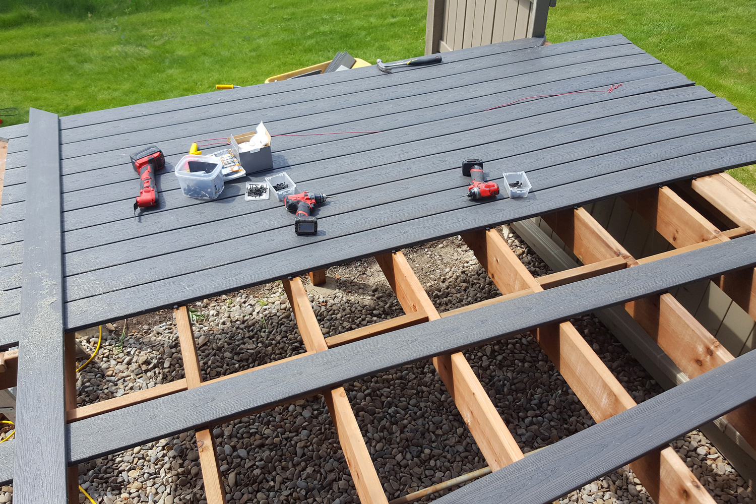 New deck constructed from a Composite Decking Material. PVC Gray plastic with a wood grain. Supports and beams are real wood,cedar.