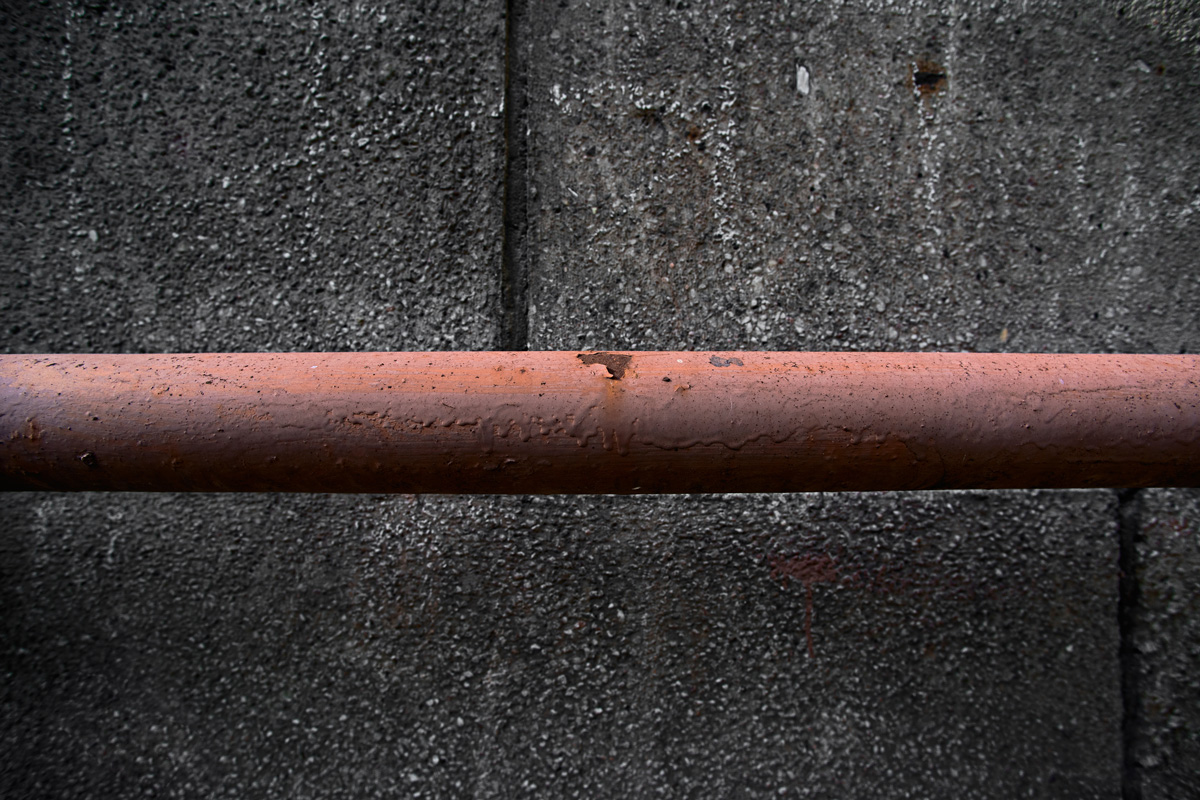 Old rusty pipe against the wall