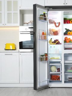 An open refrigerator filled with food in kitchen, GE Profile Refrigerator Not Cooling — What To Do?