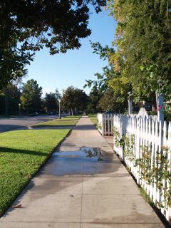 A picket fence next to a sidewalk, How Close To The Sidewalk Can I Build A Fence?
