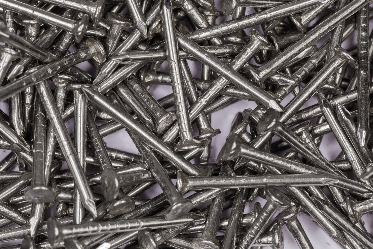 Pile of small steel nails with white anti corrosion coating