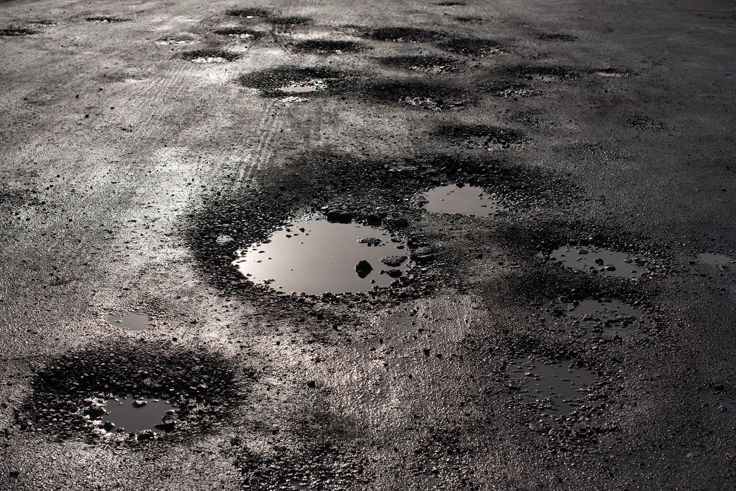 Potholes in the road looking like alien craters