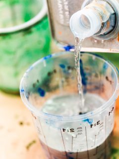 Pouring paint thinner to a cup to mix with paint, How To Mix Paint And Thinner [And Should You?]