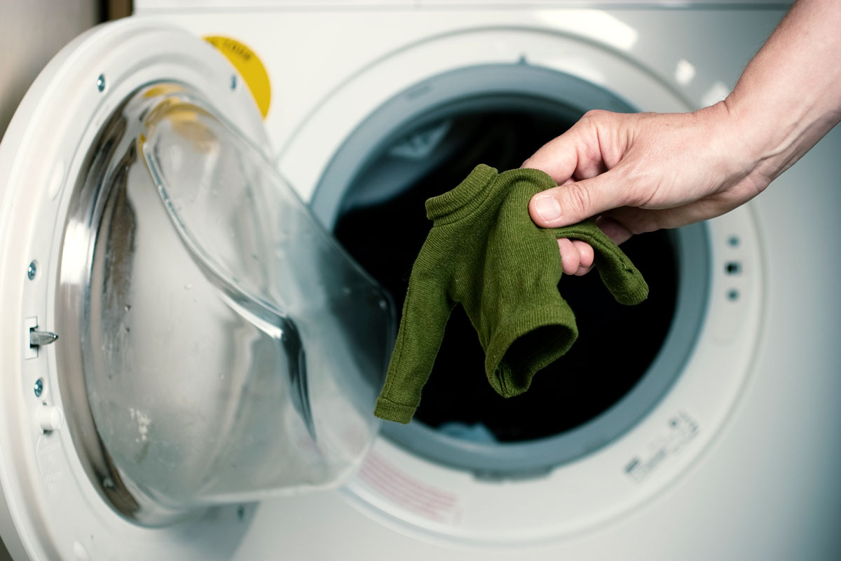 Putting polyester in a washing machine by a female hand