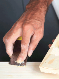 Putty knife in man's hand. DIY worker applying filler to the wood. Removing holes from a wood surface. How Long Does It Take For Wood Filler To Dry