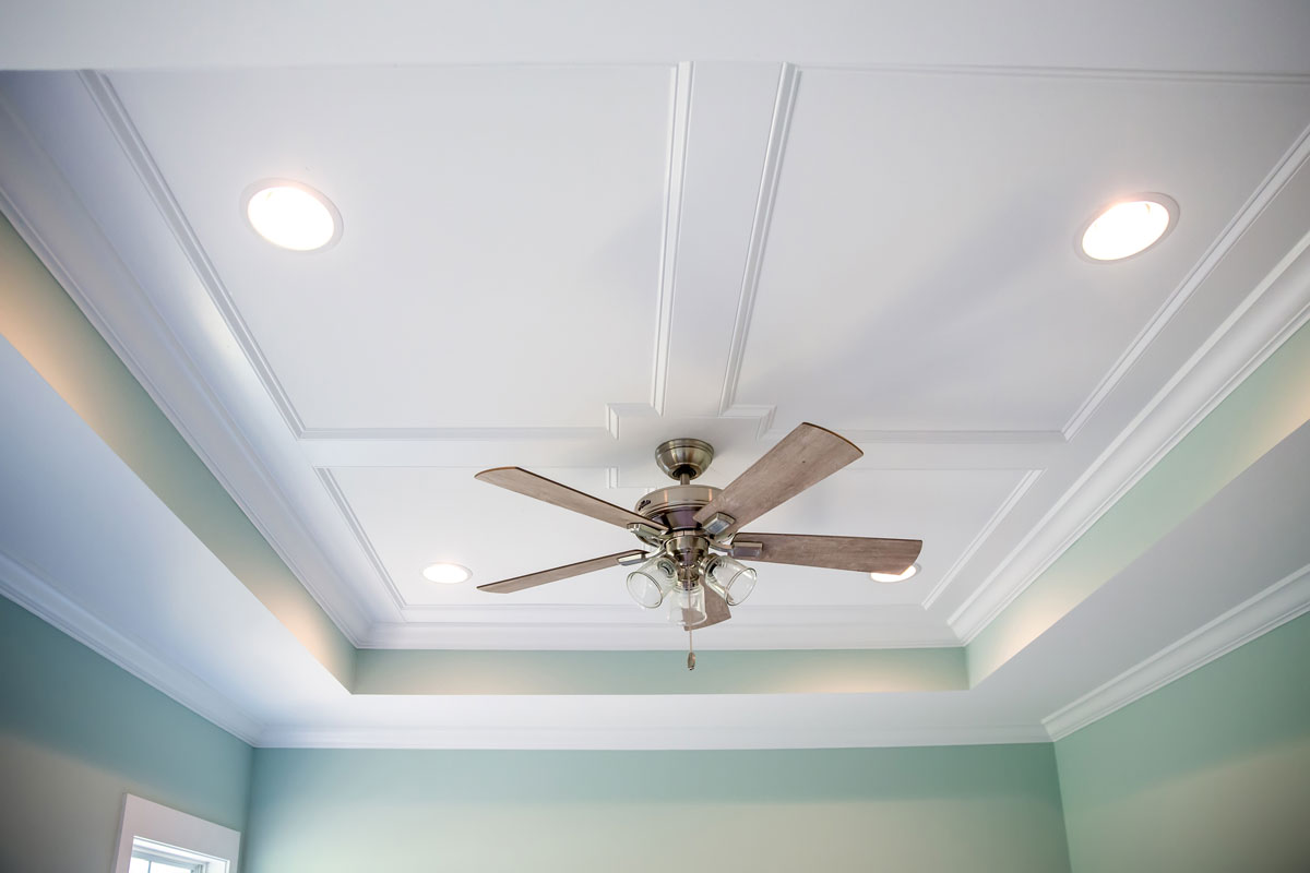 Seamless white ceiling with recessed lighting and a ceiling fan on the middle
