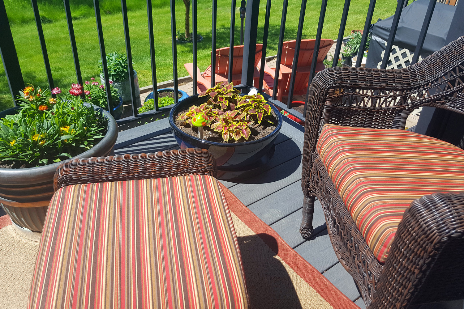 Summer pots of plants with matching wicker deck furniture and cushions, Stylish And Sophisticated Residential Deck Decor