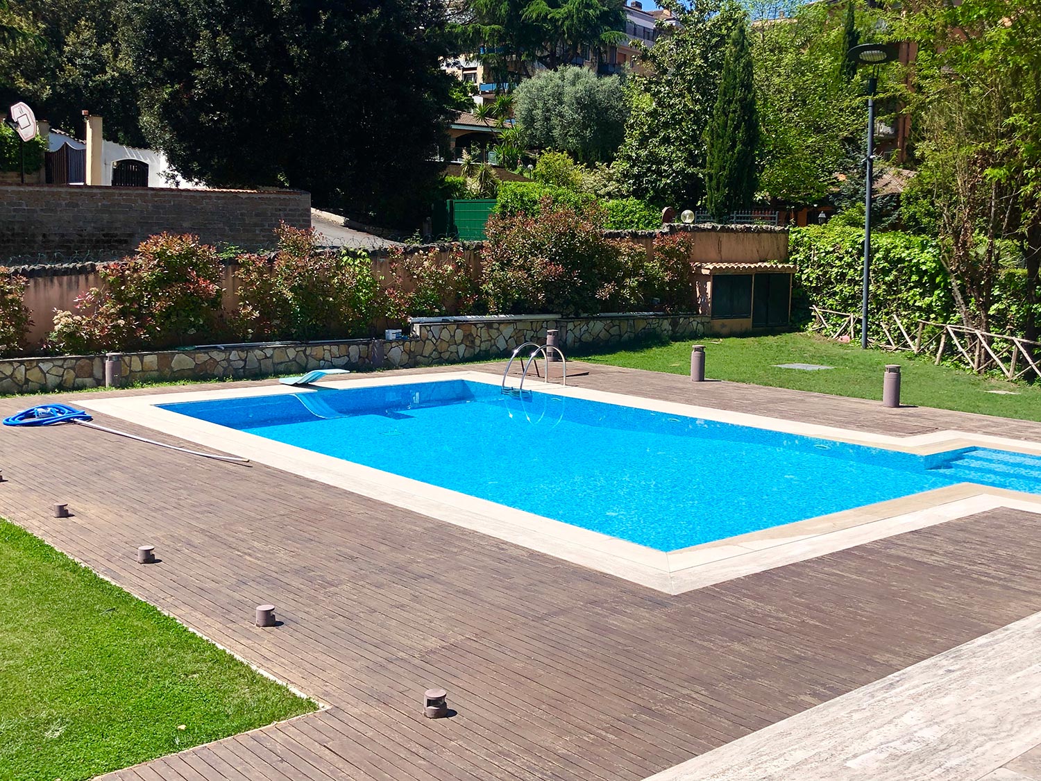 Swimming pool in home garden with wooden floor
