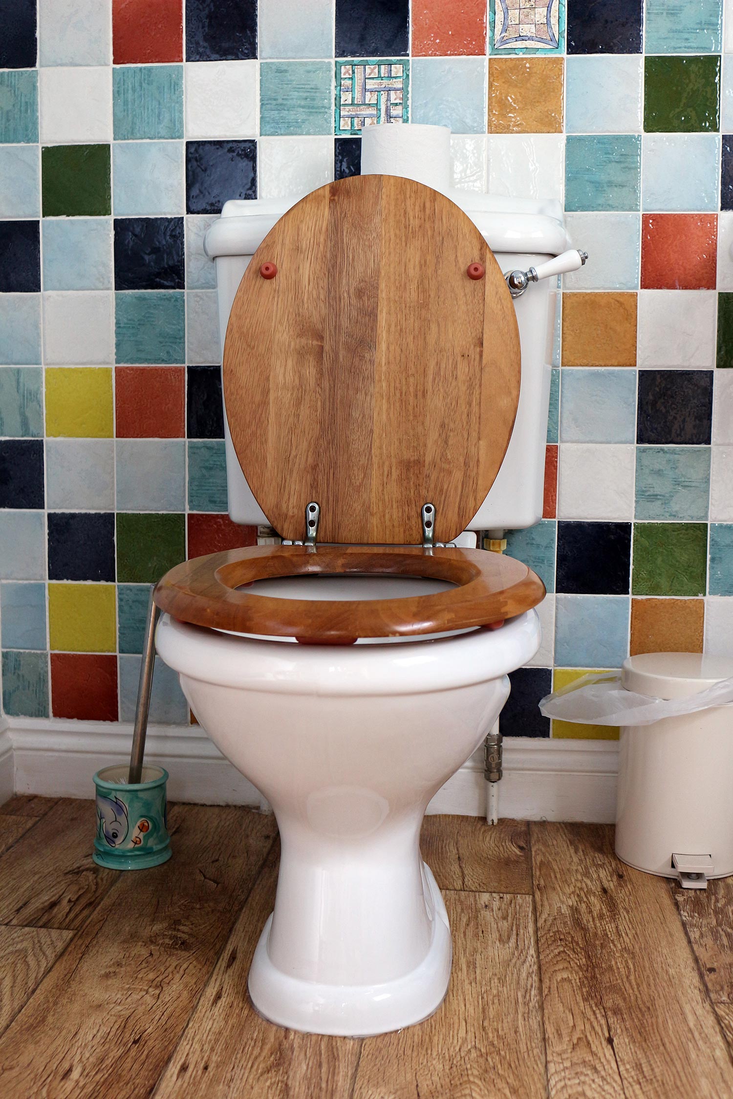 Toilet in a colorfully tiled bathroom