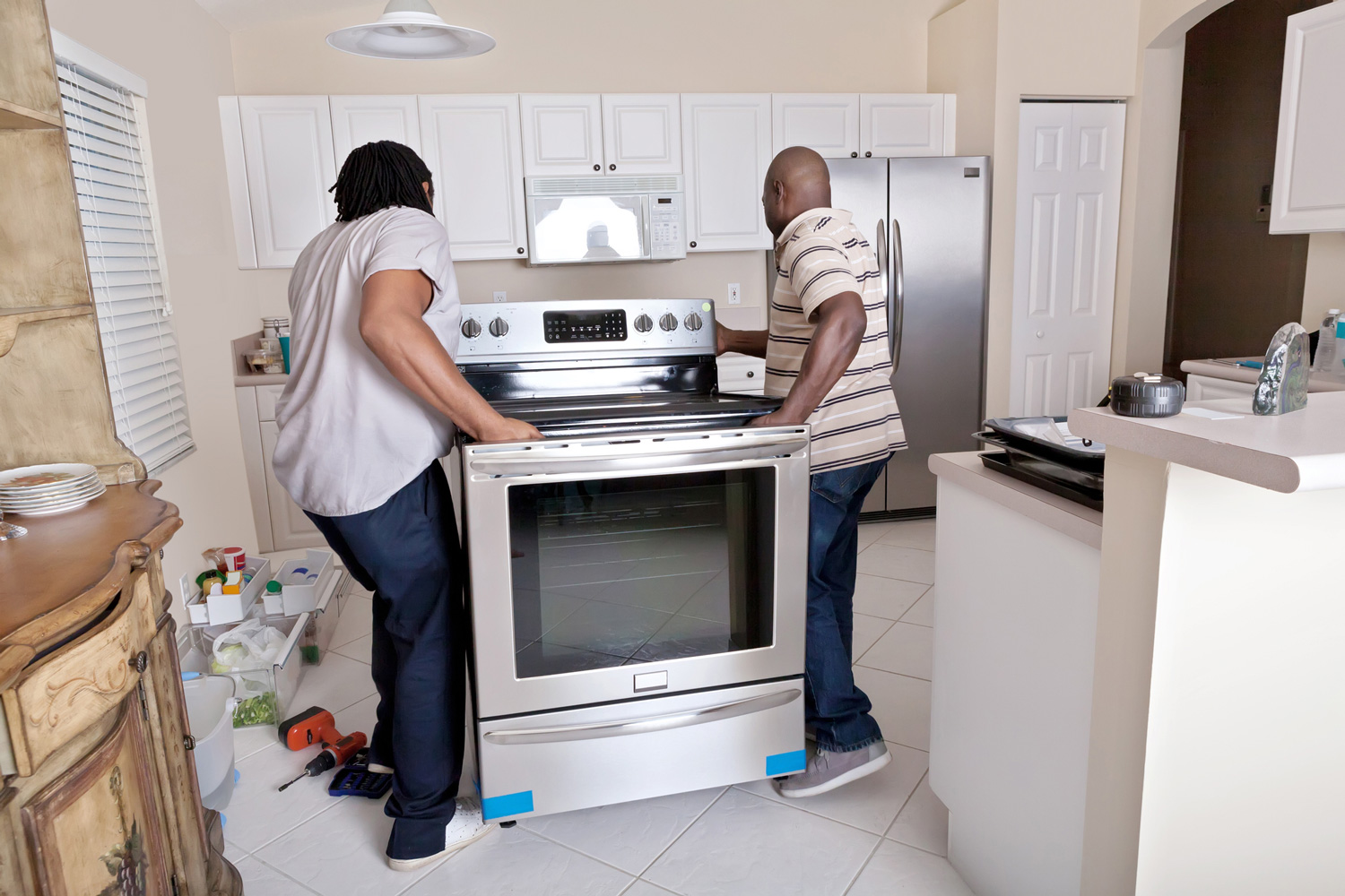 Two delivery men installing an oven