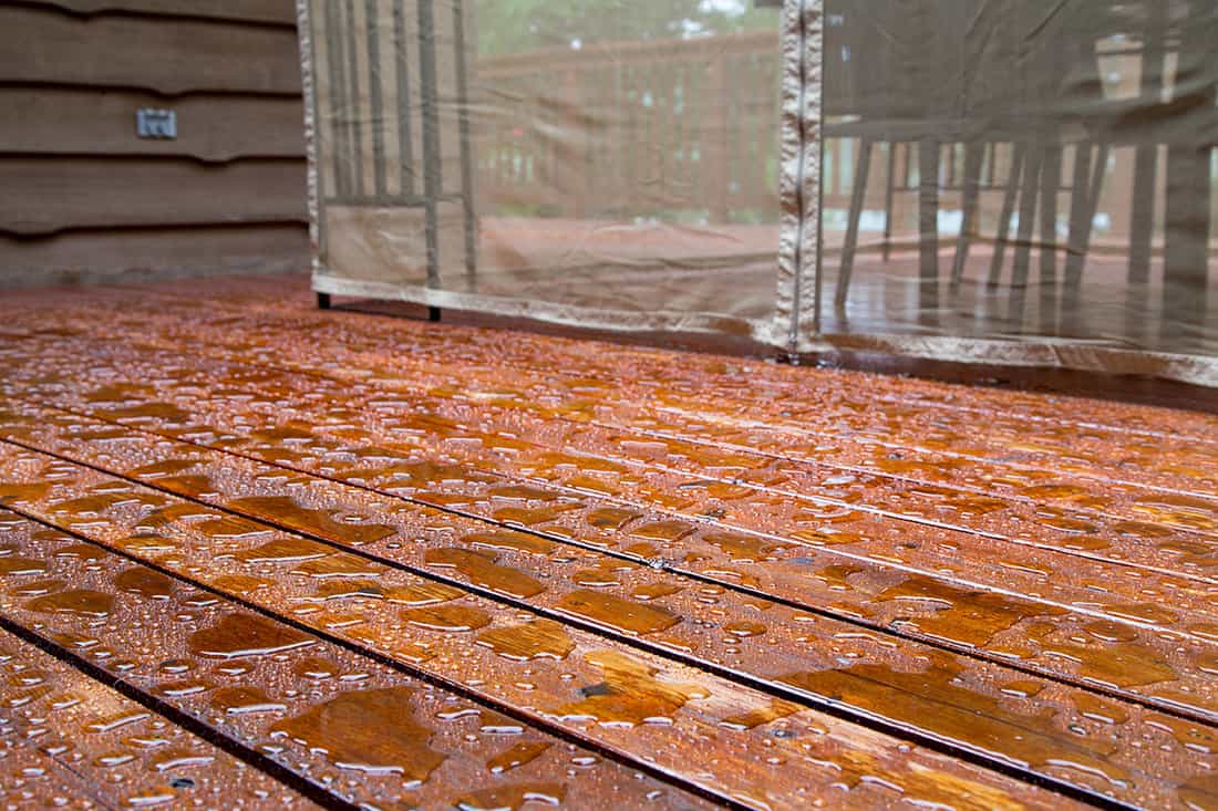 Water beads up on a freshly sealed wood deck after a morning rainstorm at the cottage
