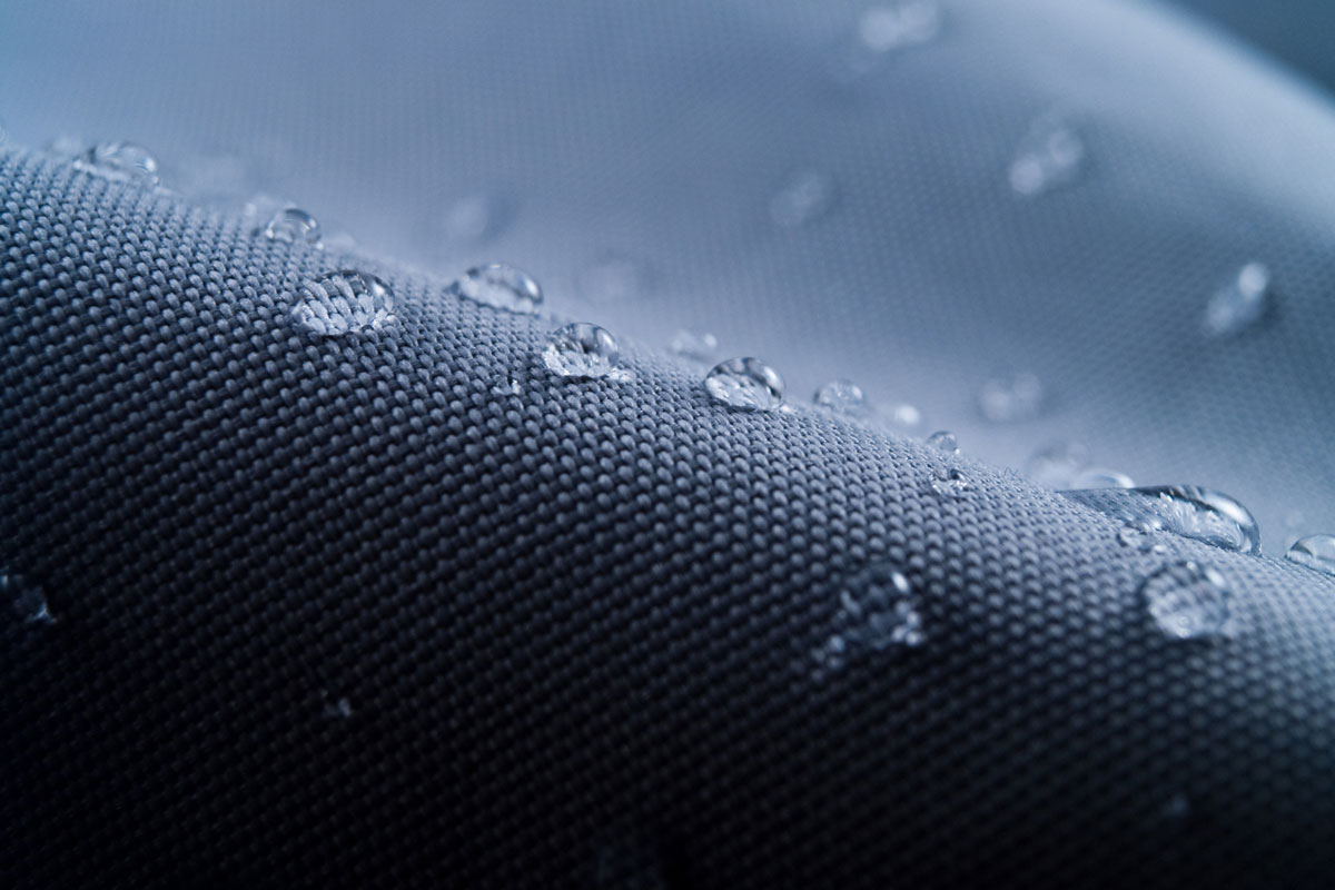 Waterproof textile clothing blue with water on a polyester fabric
