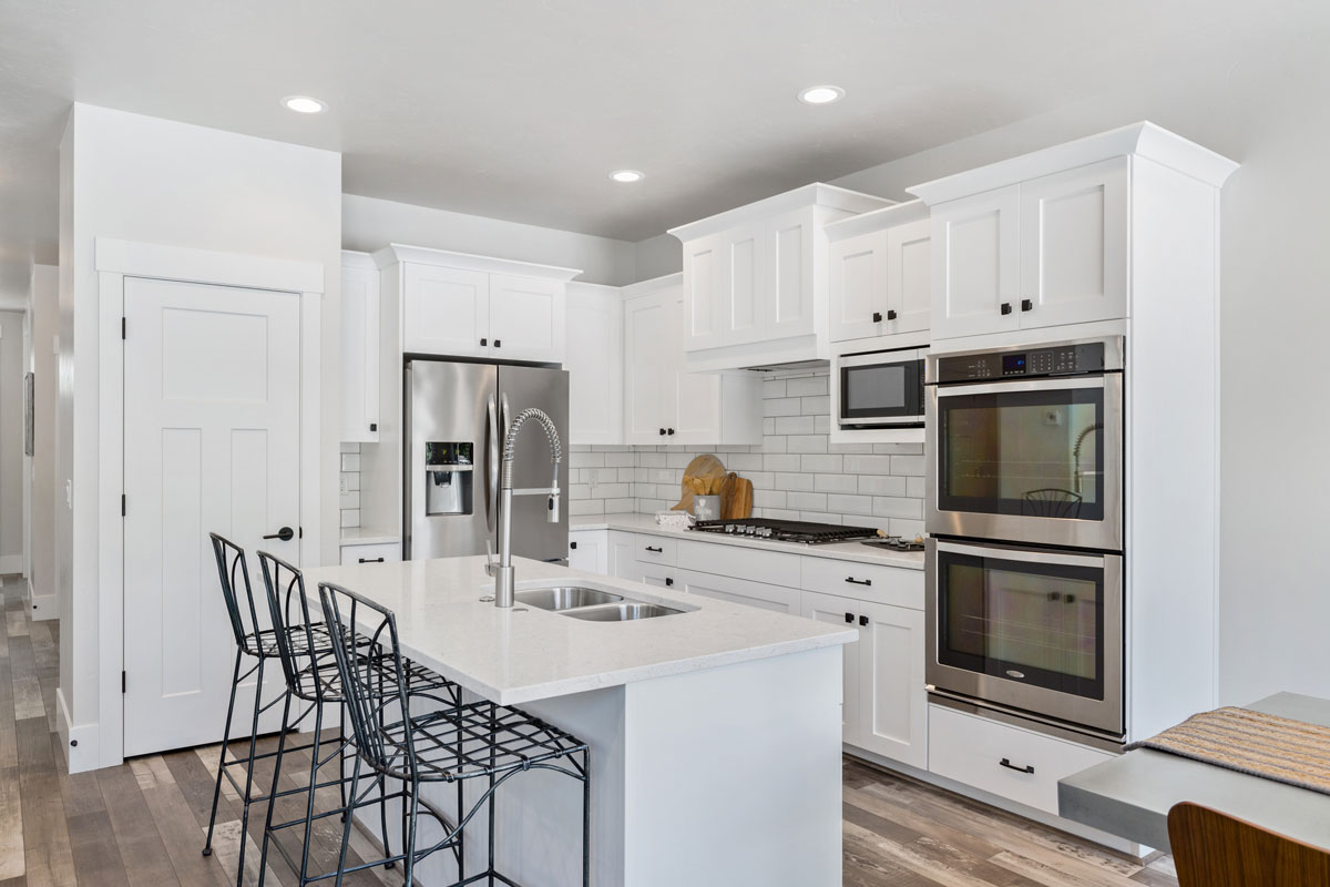 White kitchen with smaller island and stainless steel appliances