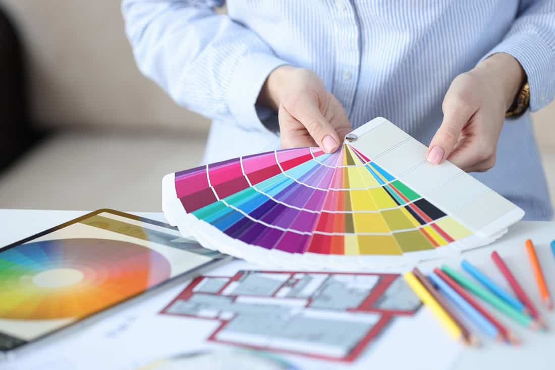 Woman holding color palettes paint scheme