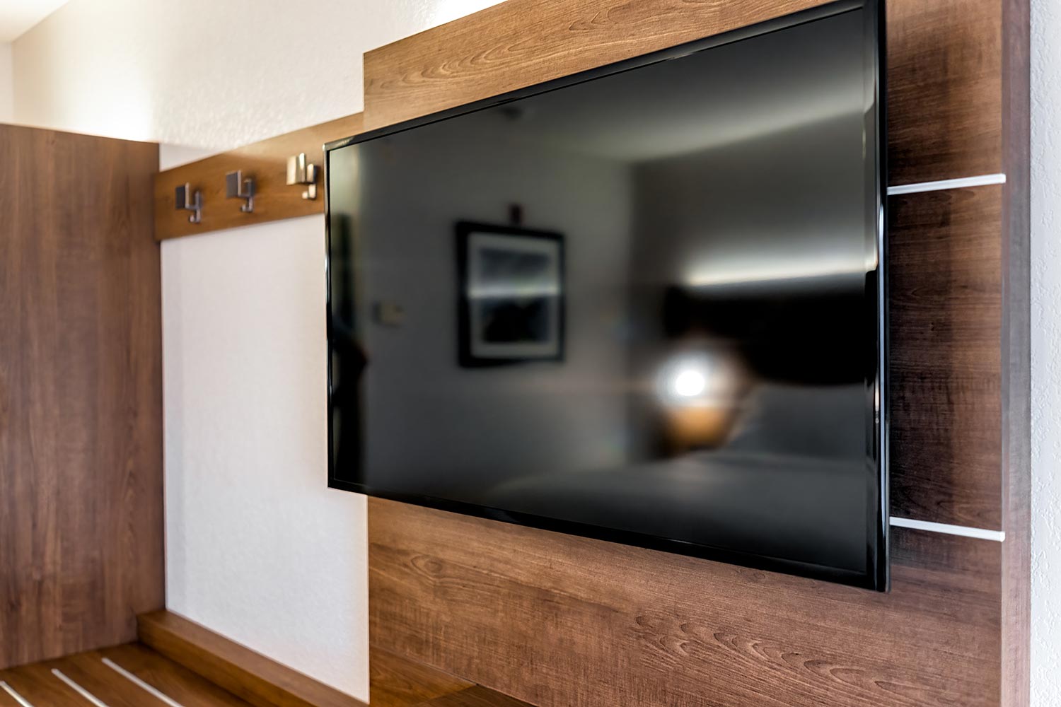Wooden modern style hotel suite room with tv television mounted to wall