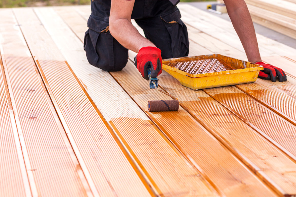 Worker staining the wooden deck