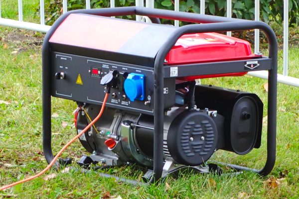 Working portable electric generator on green grass