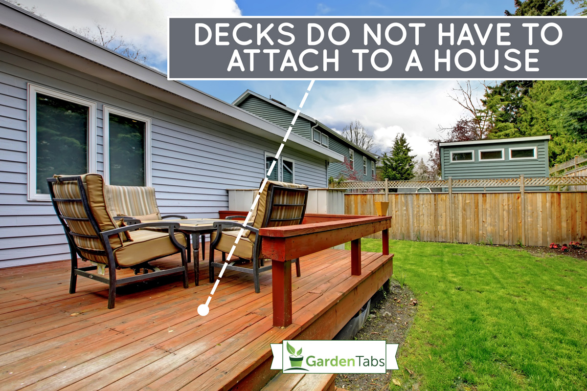 Grey small house with simple deck and outdoor chairs, Do Decks Have To Be Attached To The House?