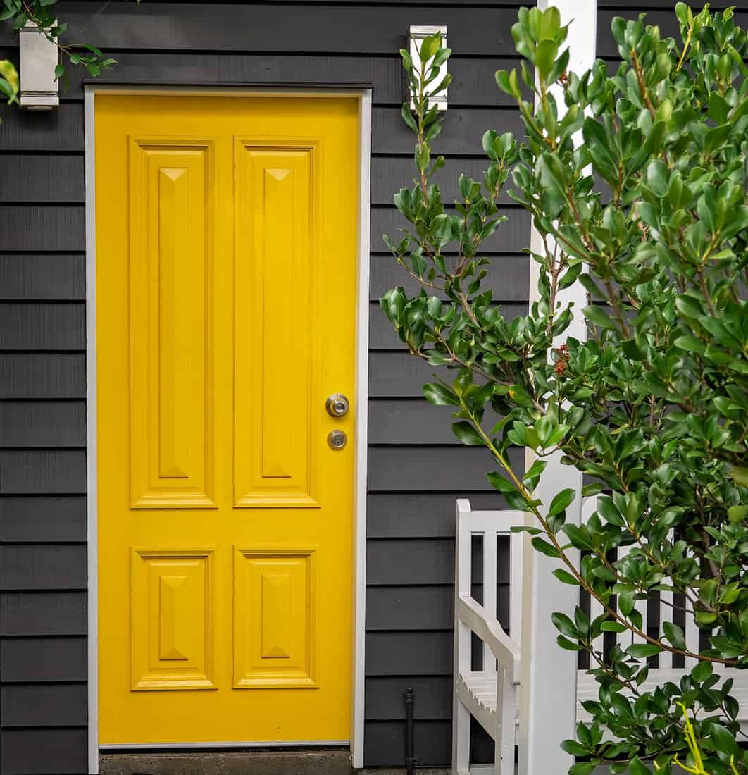 A bright yellow front entrance door in a renovated old Queensland home