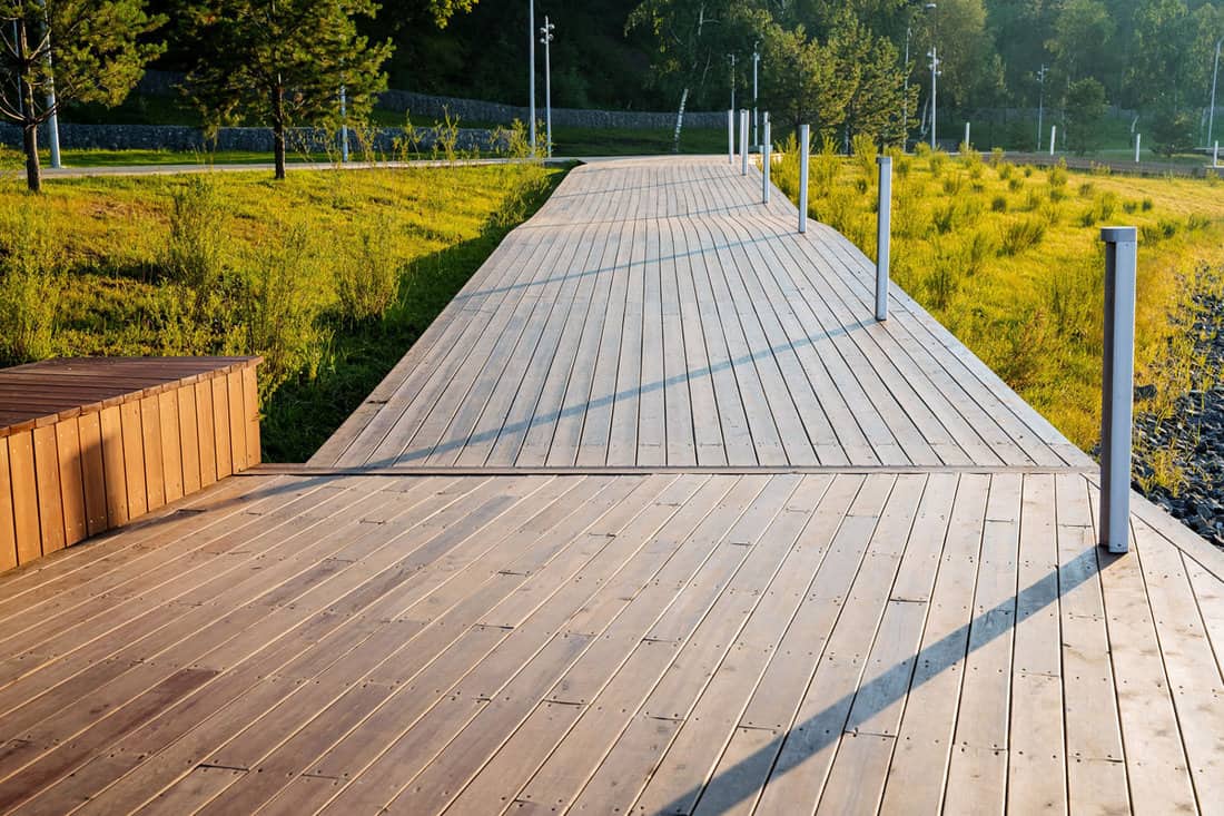 A pedestrian road made of boards, a path for walking in the park, an eco trail in the countryside, care for the environment