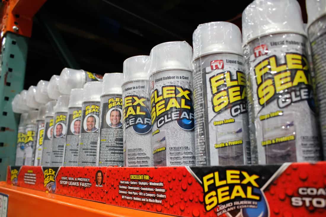 A store shelf filled with lots of Flex seal containers
