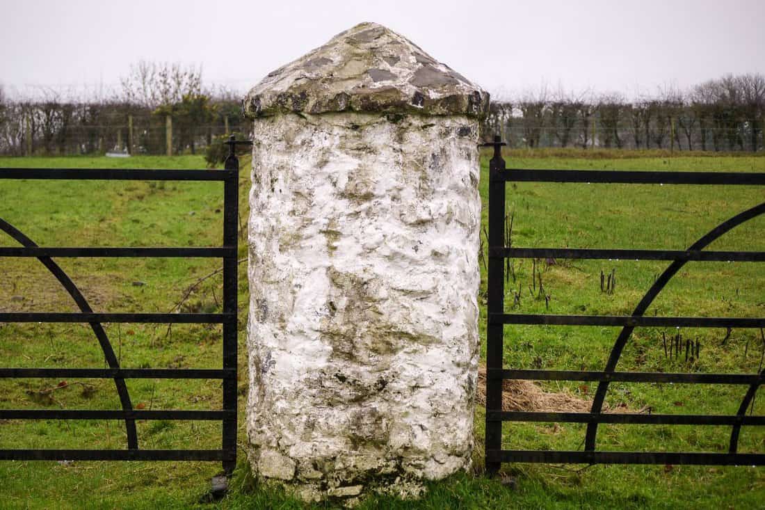 A traditional Irish countryside scene with closed farmyard gates.