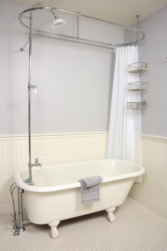 A white bathtub with a long stainless steel shower head