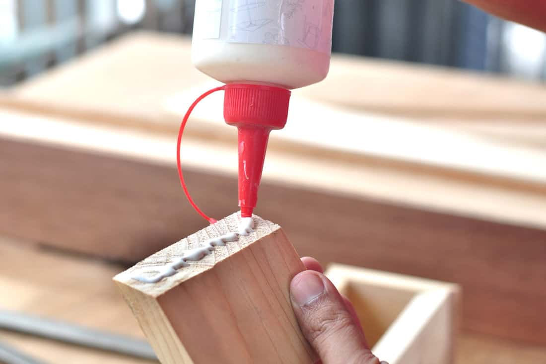 Applying wood glue to the a wooden workpiece