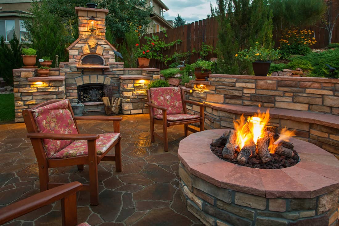 Beautiful backyard at twilight that includes a pizza oven and fire pit.